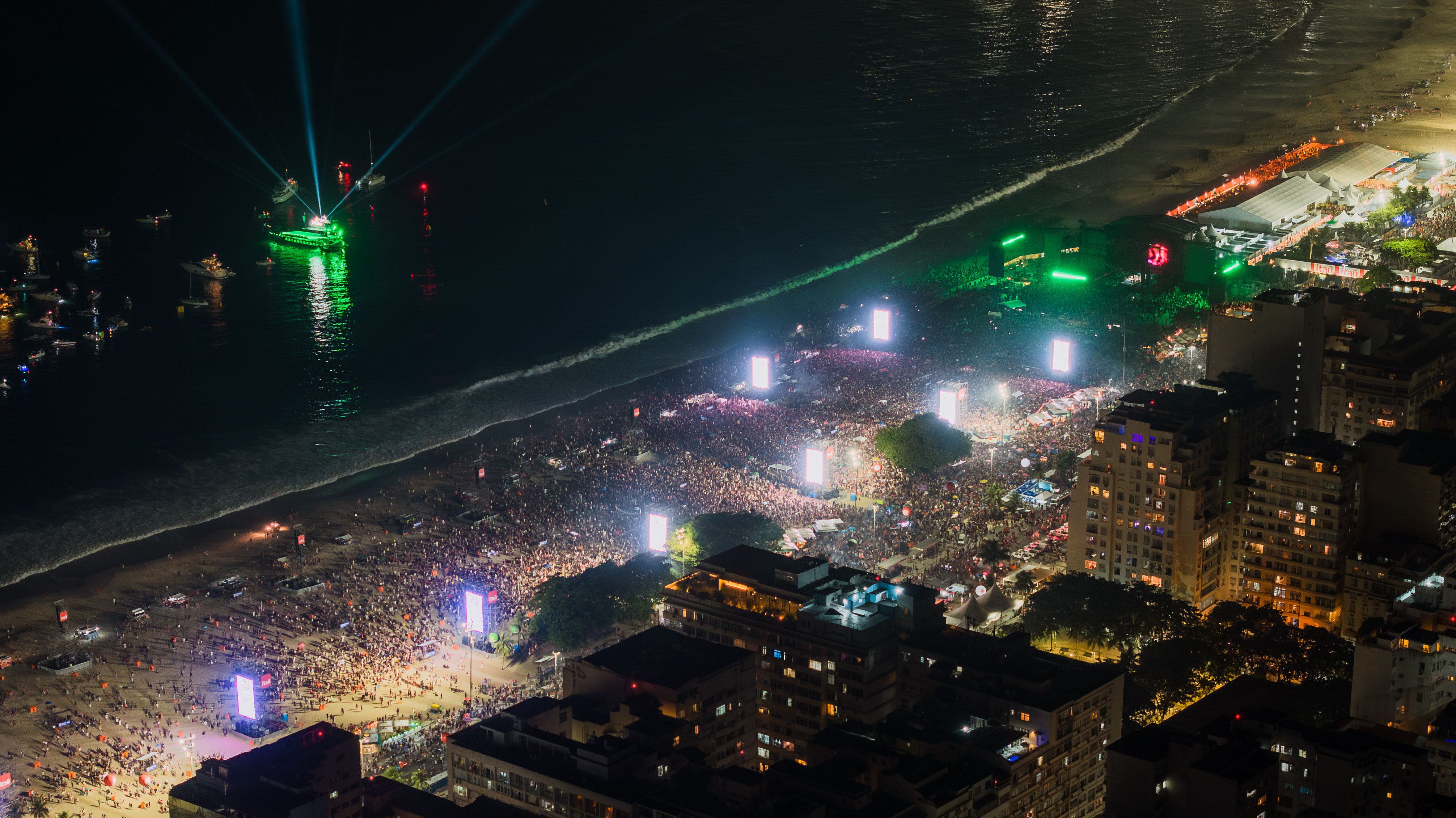 Aerial view of a nighttime celebration along Copacabana Beach in Rio de Janeiro.
